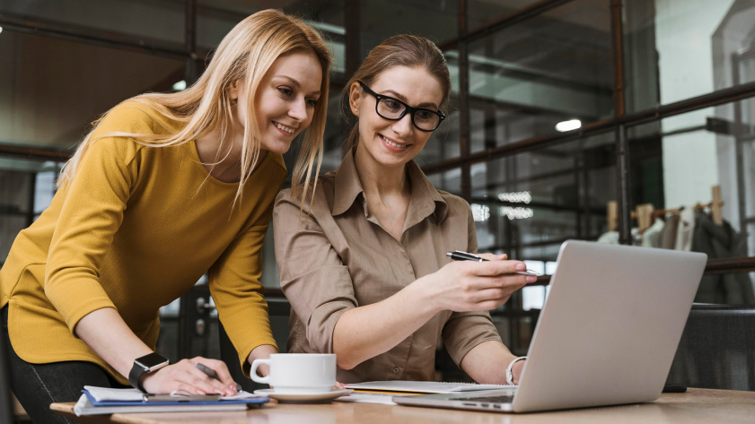young smiley businesswomen working with laptop desk scaled 1 1